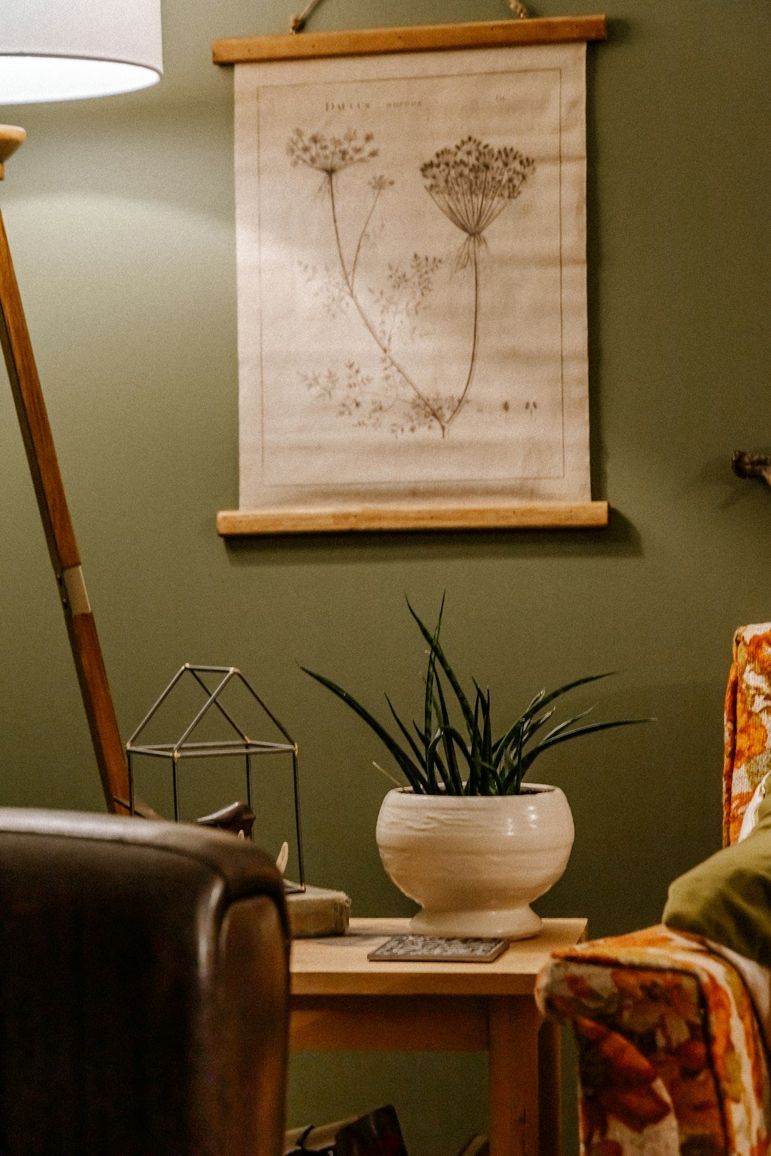 a living room with a chair and a table with a plant on it
