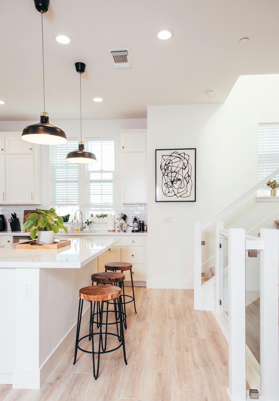A kitchen with a wooden floor and white walls