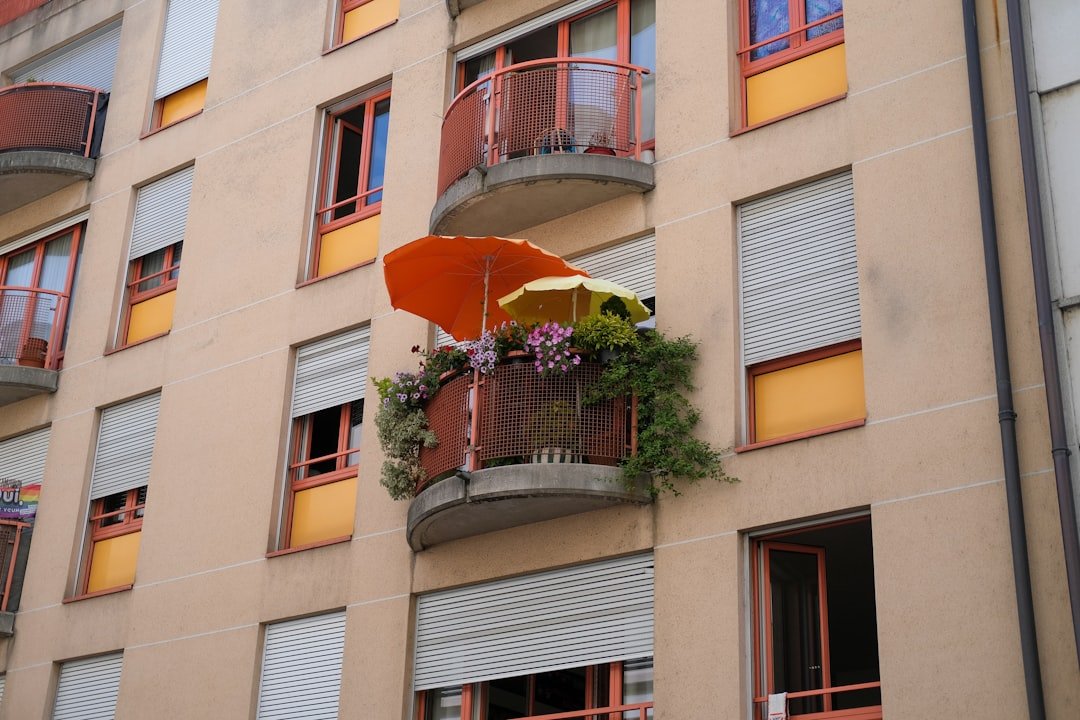 a building with a balcony and a potted plant on the balcony