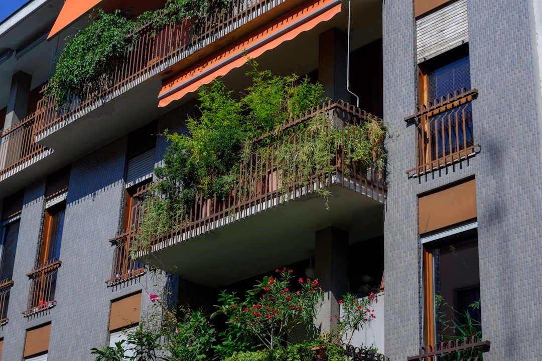 A tall building with balconies and plants on the balconies
