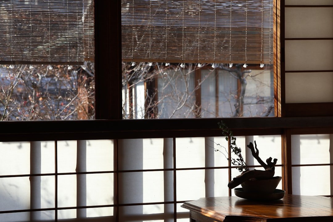 A room with a large window and a table with a vase on it