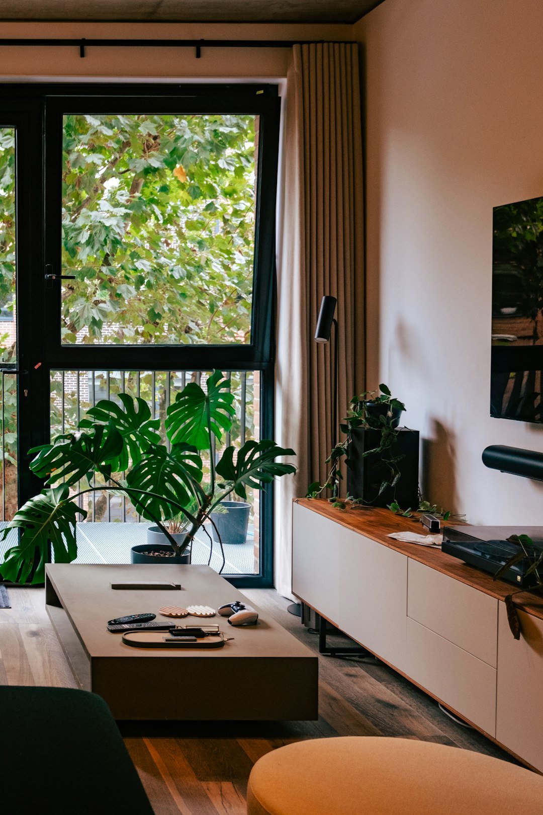 a room with a table and a window with plants