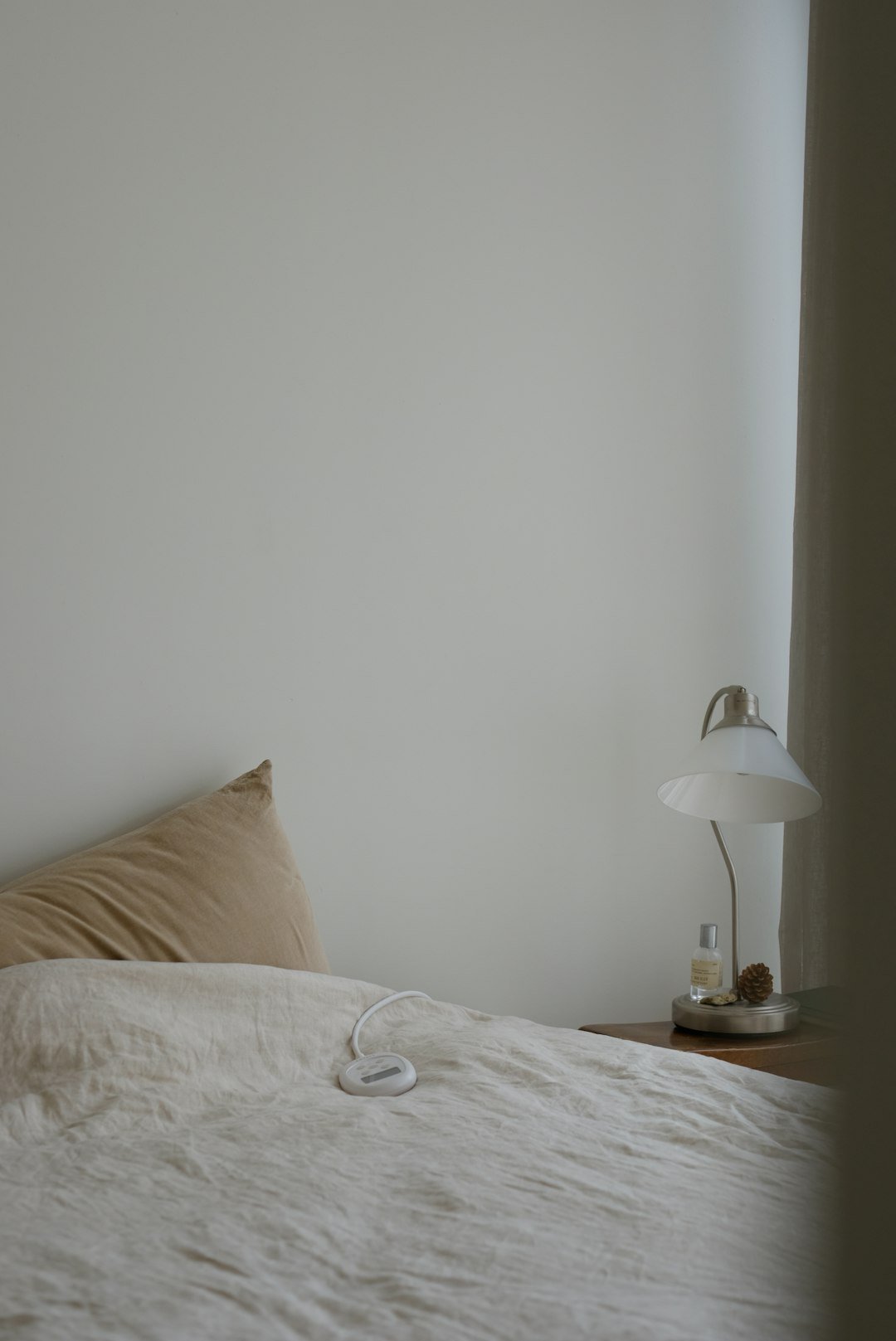 A bed with a white comforter and a lamp