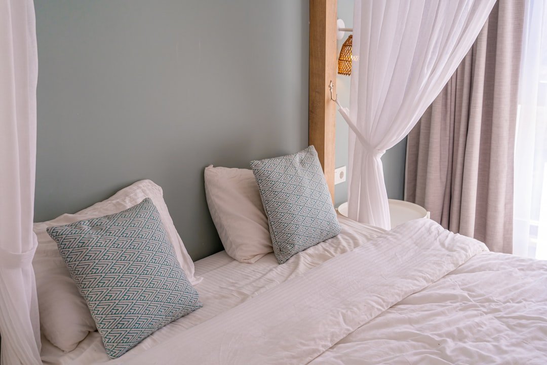 a bed with a white comforter and two pillows