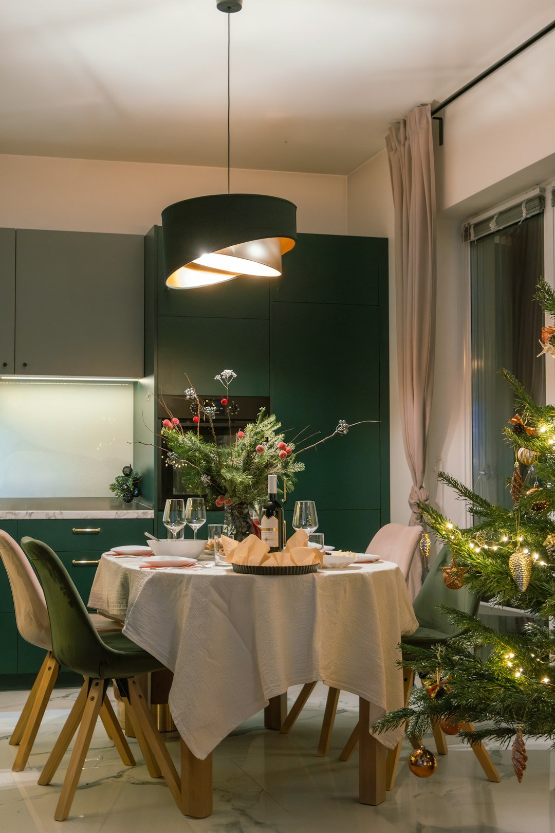 A dining room with a christmas tree in the corner