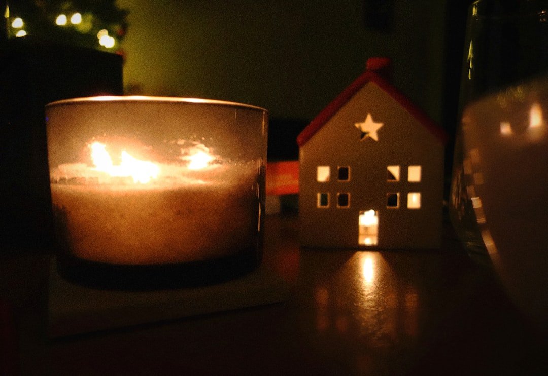 a lit candle sitting on top of a wooden table
