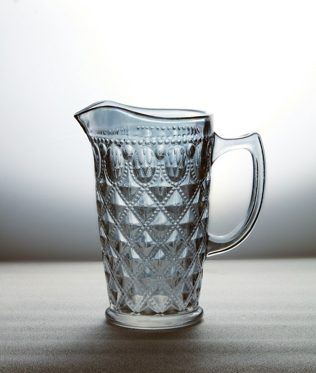 An elegant, diamond-patterned glass pitcher.