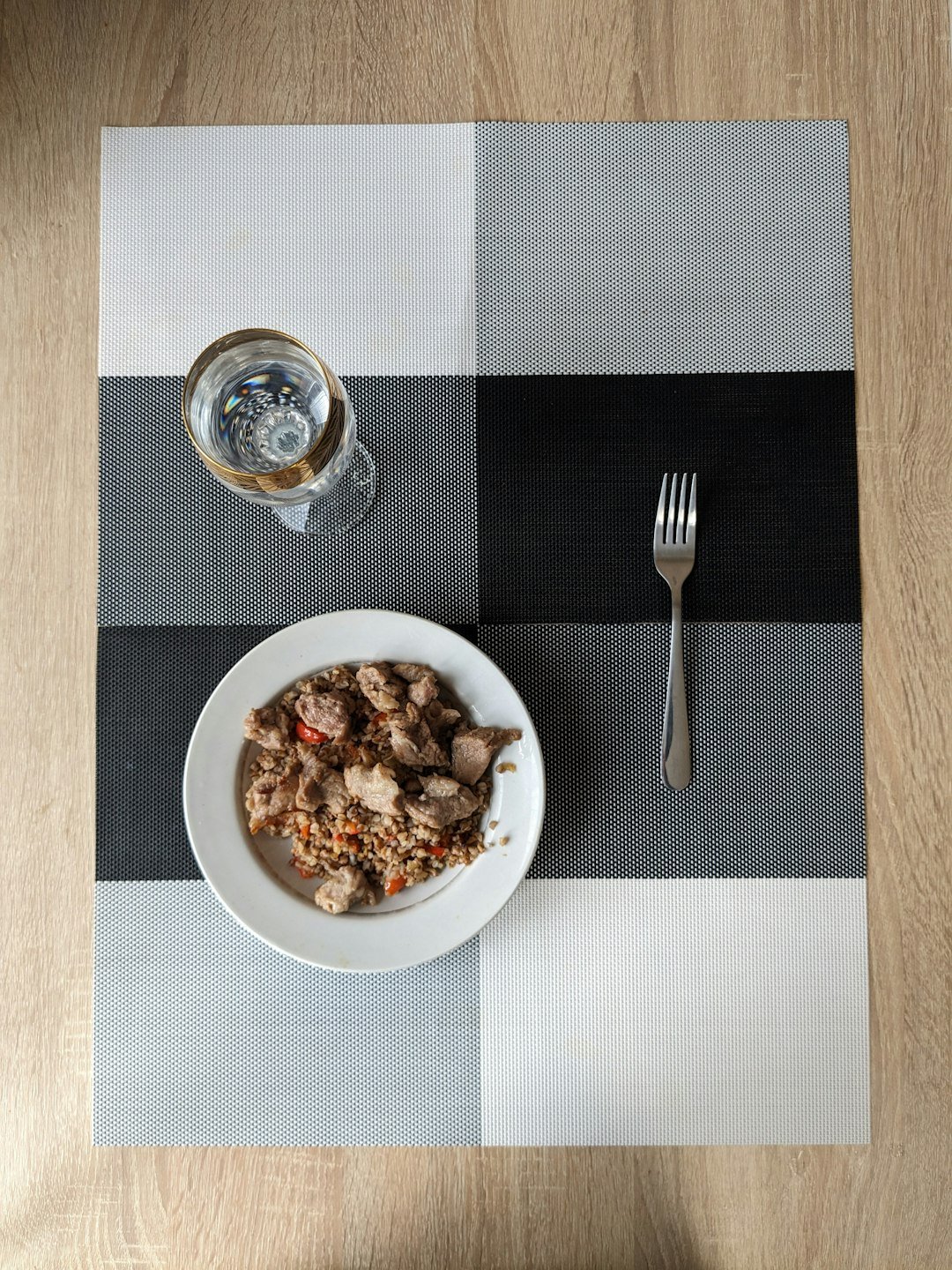 a plate of food and a glass of water on a table