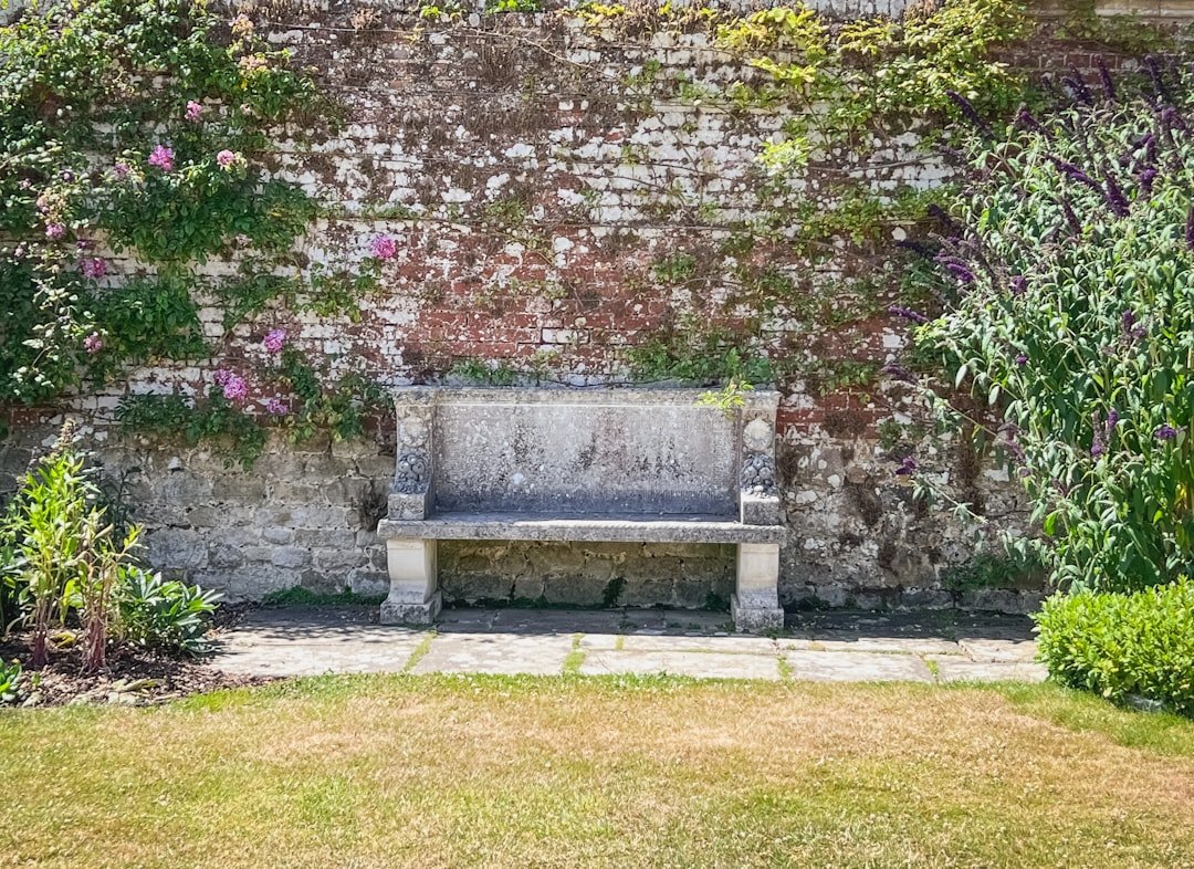 A stone bench sits against a brick wall.