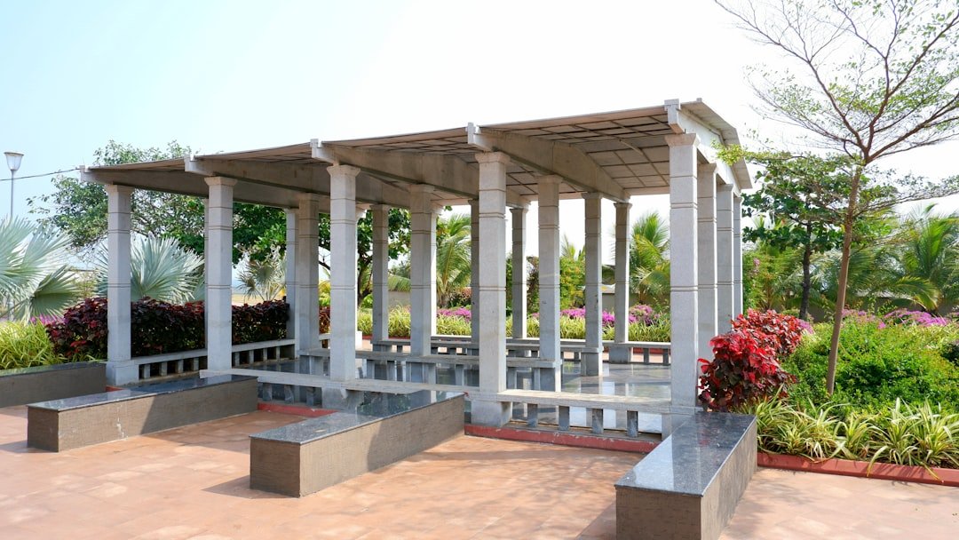 A pavilion with benches stands in a park.
