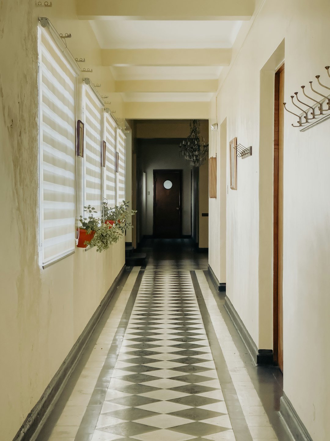 A long hallway with a checkered floor and white walls