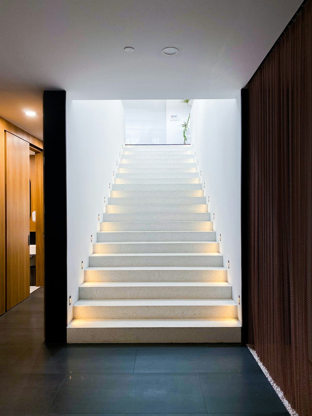 white staircase with brown wooden door