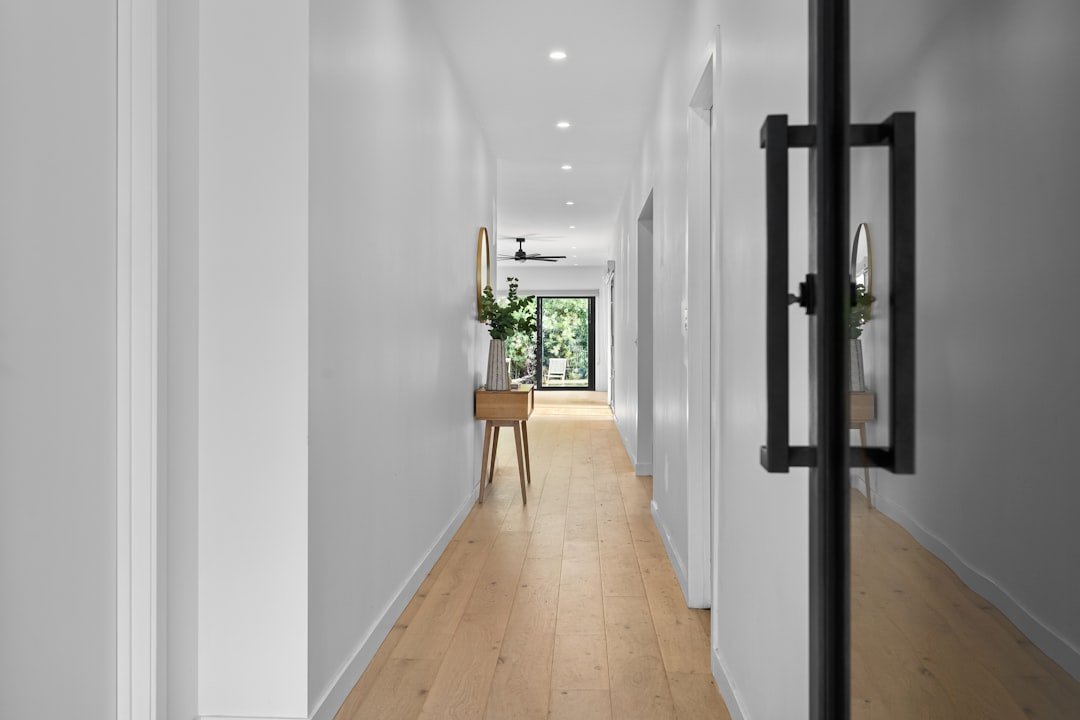 A hallway with a wooden floor and white walls