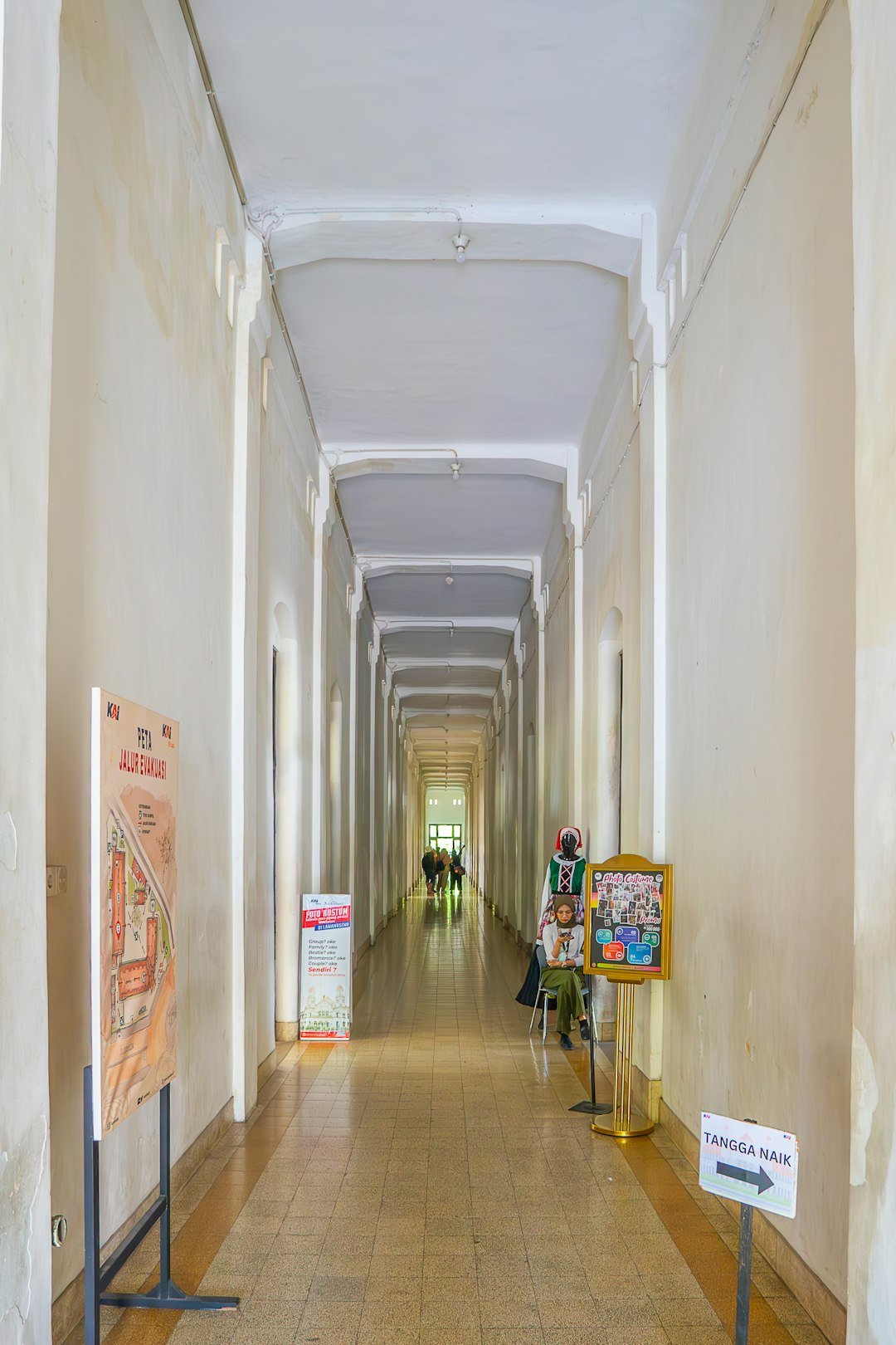 A long hallway with posters and signs on the walls