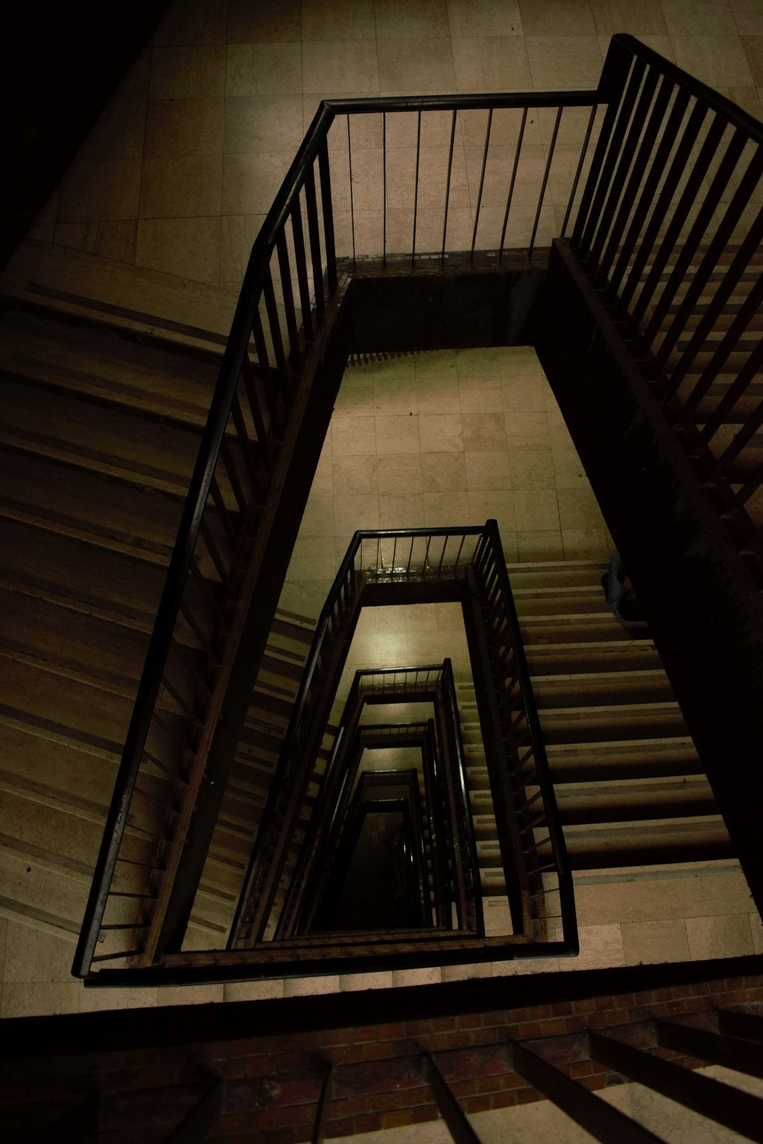 a spiral staircase in a building with a clock on the wall