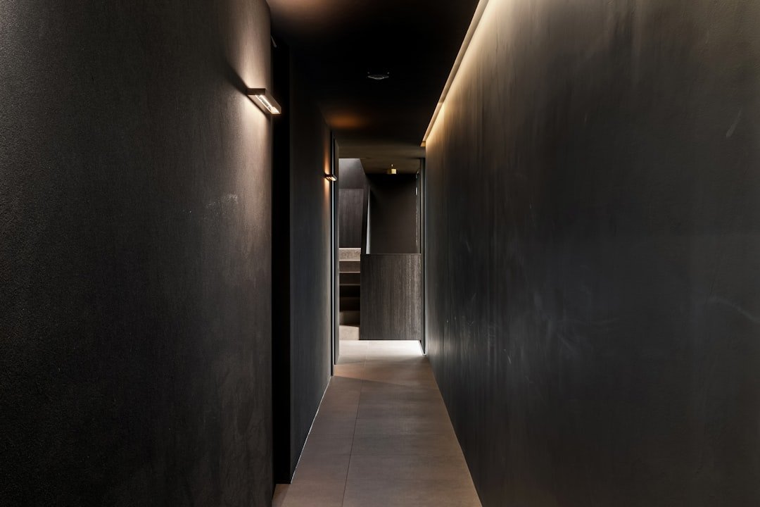 A long hallway with black walls and a white floor