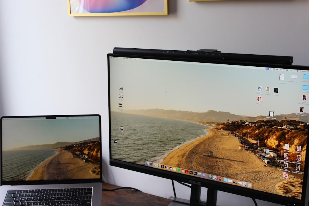 a laptop computer sitting on top of a desk next to a monitor