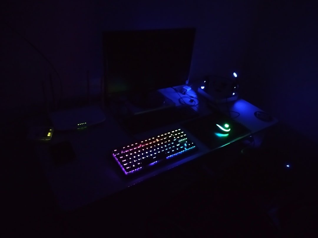 a computer desk with a keyboard and mouse lit up in the dark