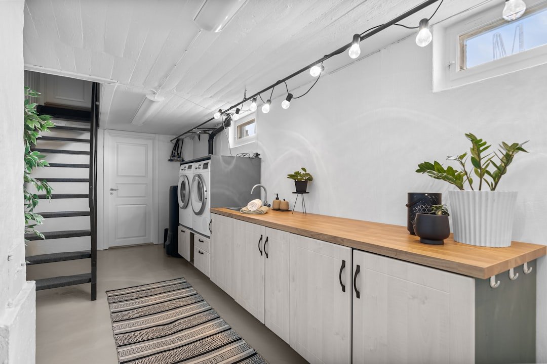 A kitchen with a sink, stove, and a washer and dryer