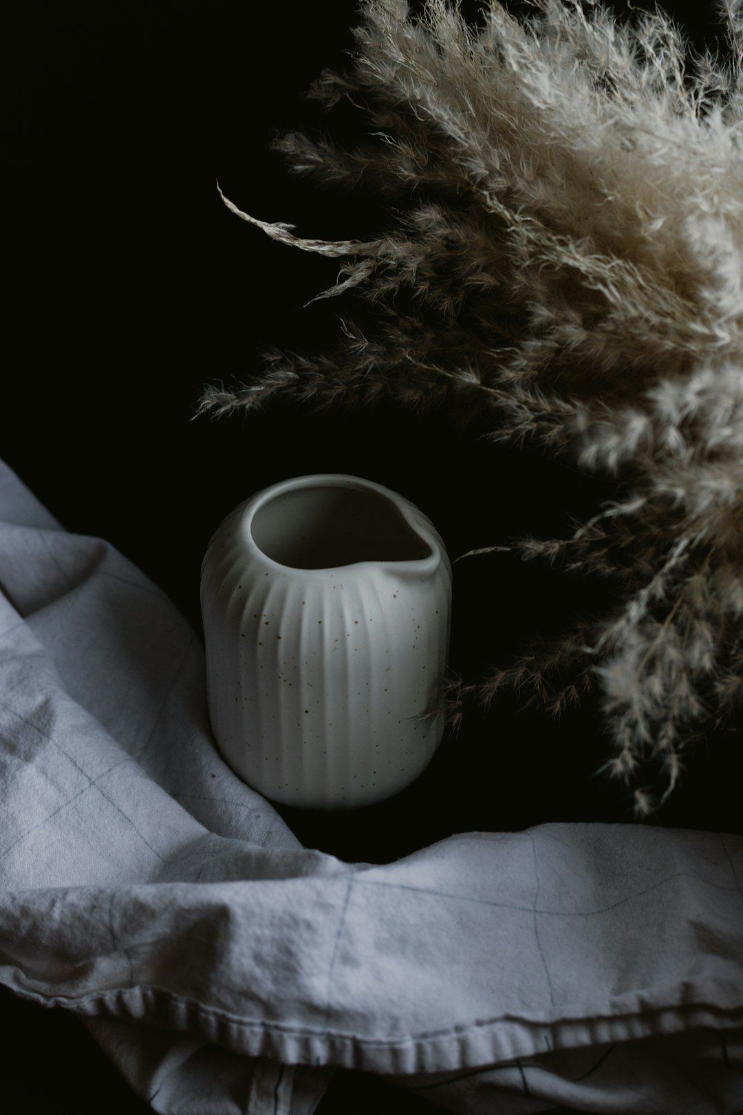 white ceramic mug on white textile