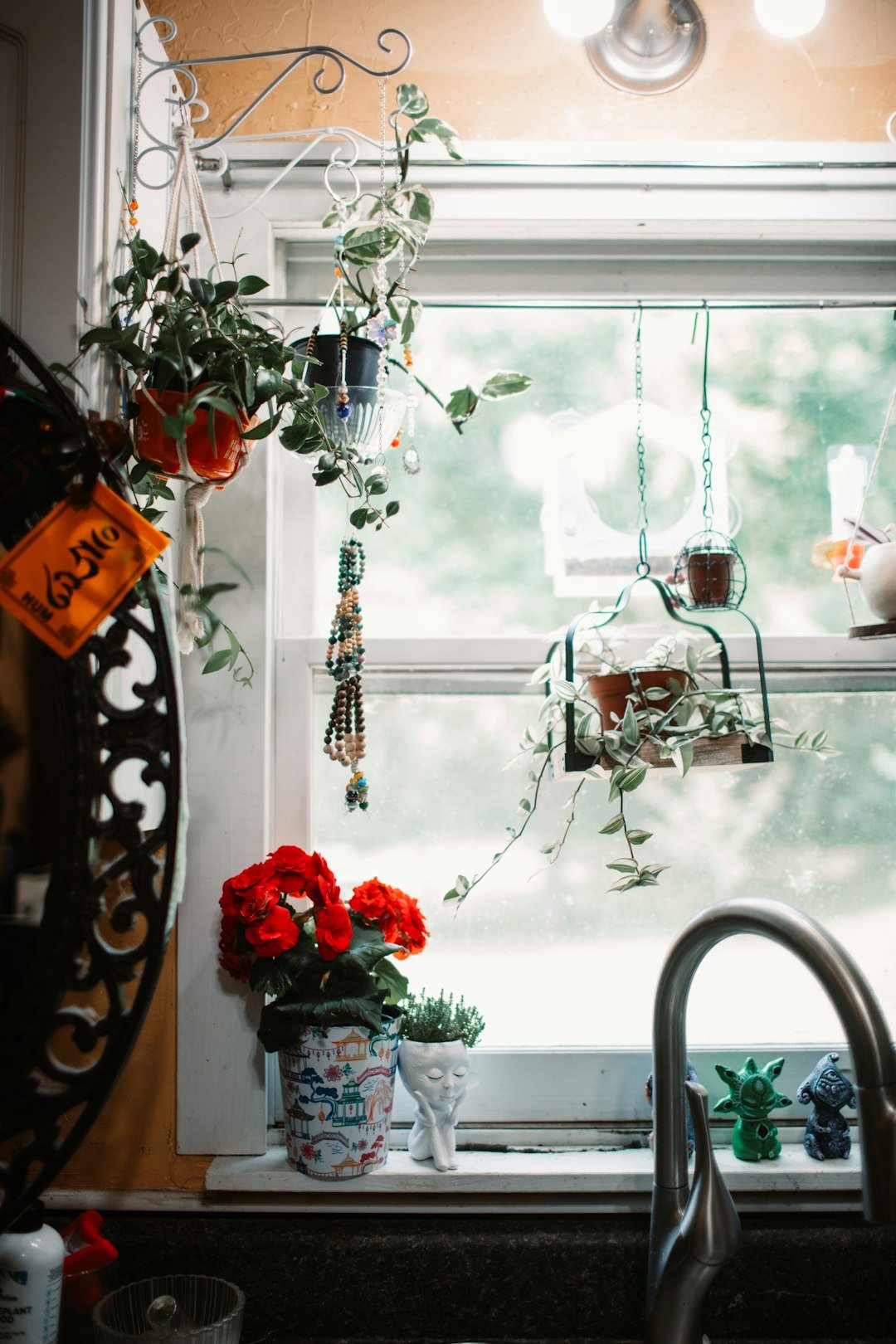 a kitchen window with a sink and a window sill filled with potted plants