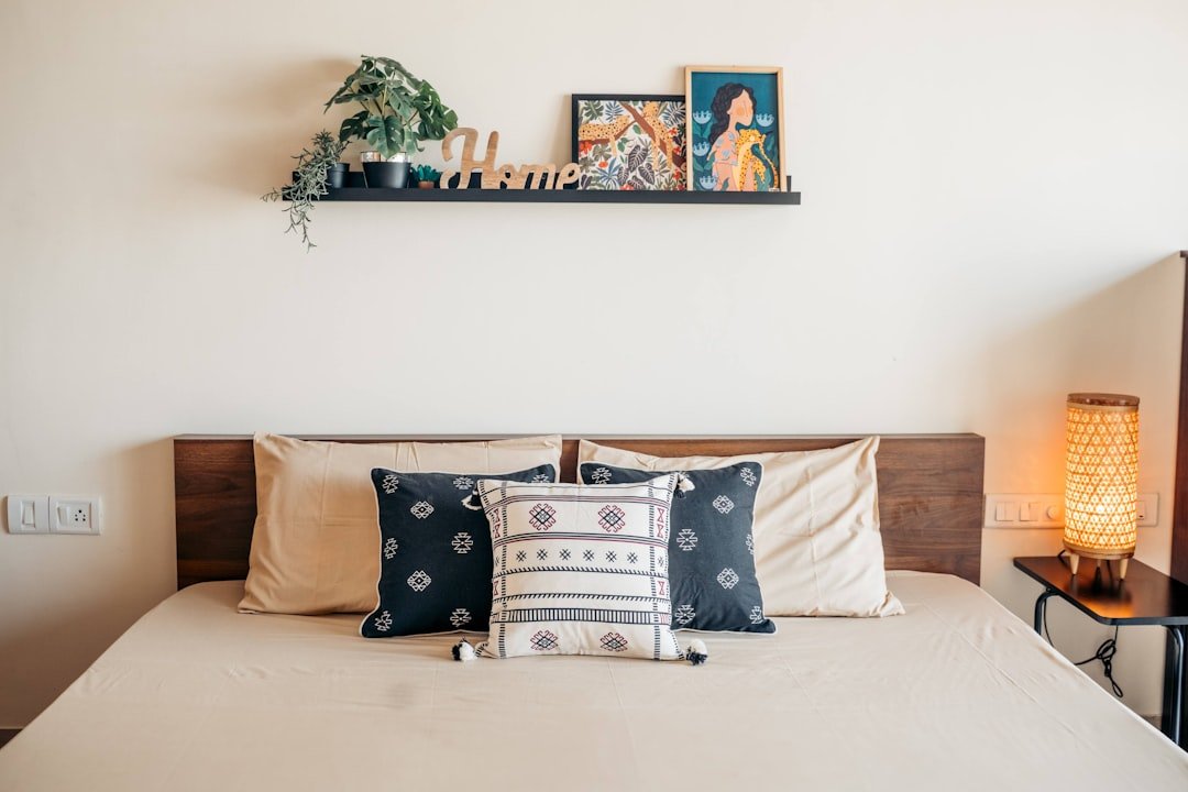 A cozy bedroom with pillows and a shelf.