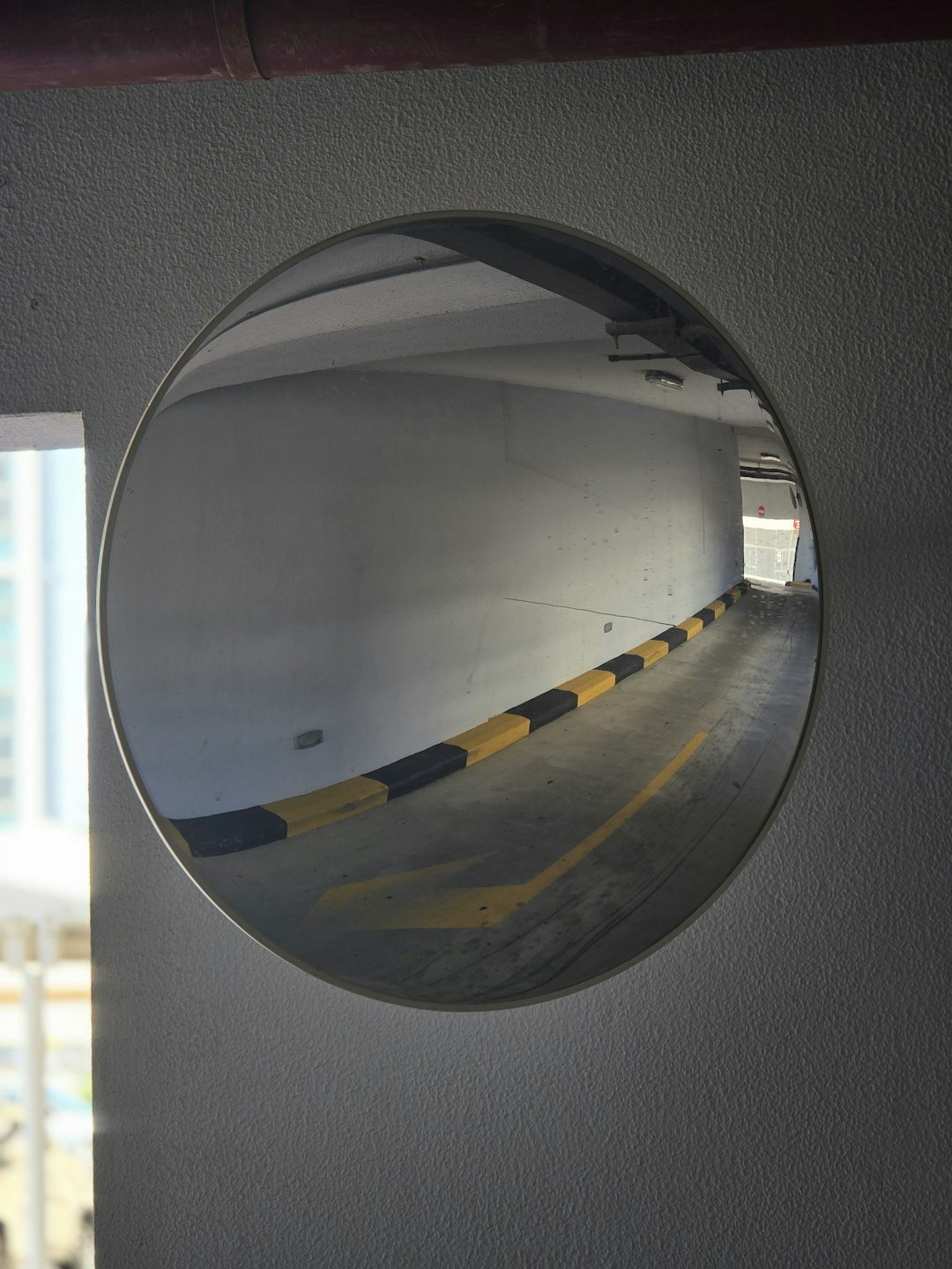 A round mirror hanging on the side of a wall