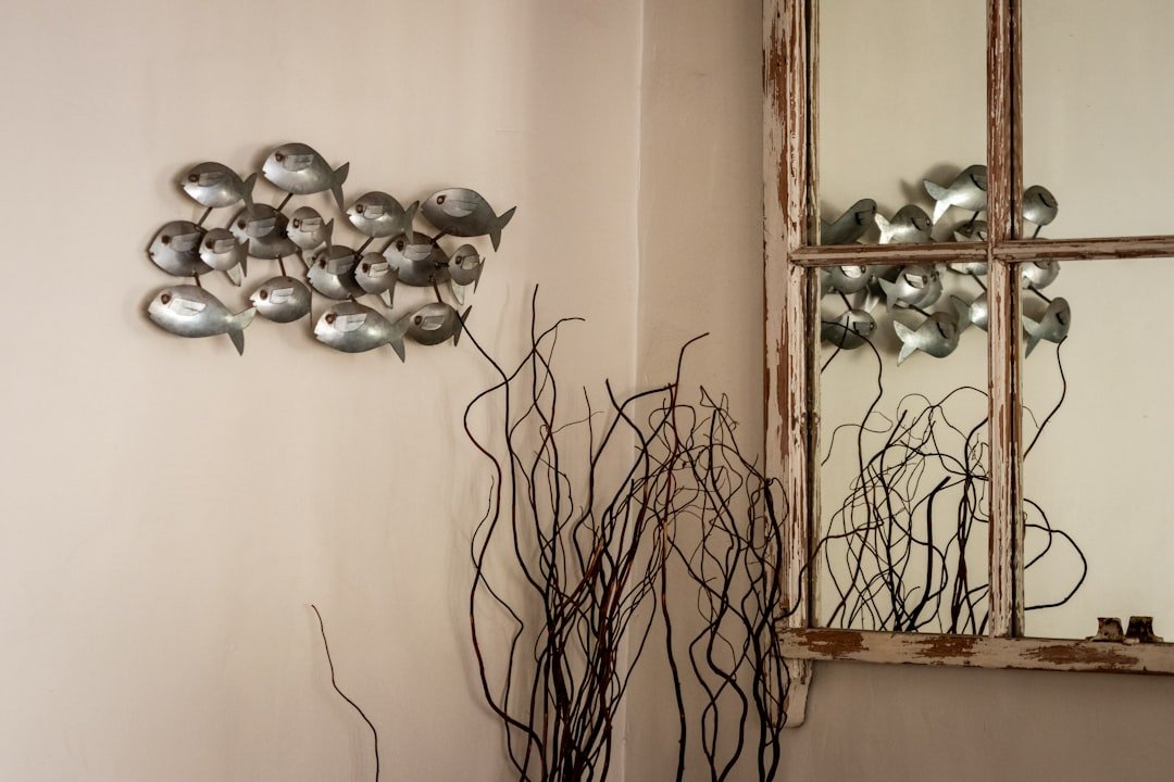 A room with a mirror and a vase on a table