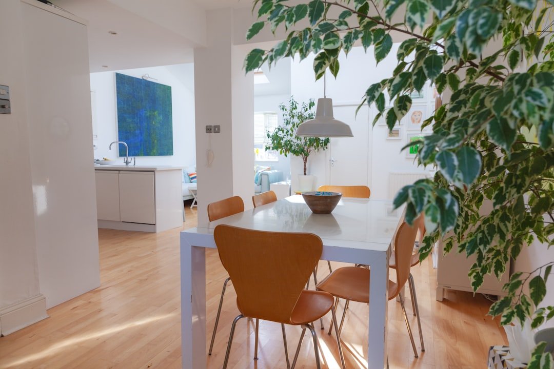 a dining room table with chairs and a bowl of fruit on it