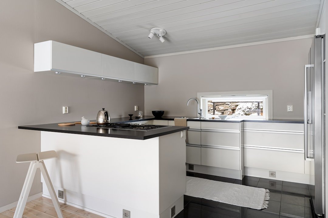 A white kitchen with a black counter top