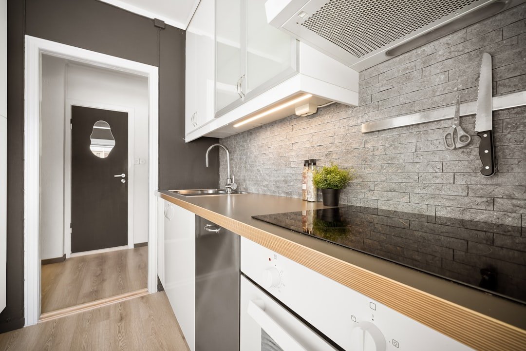 A kitchen with a sink, stove, and dishwasher
