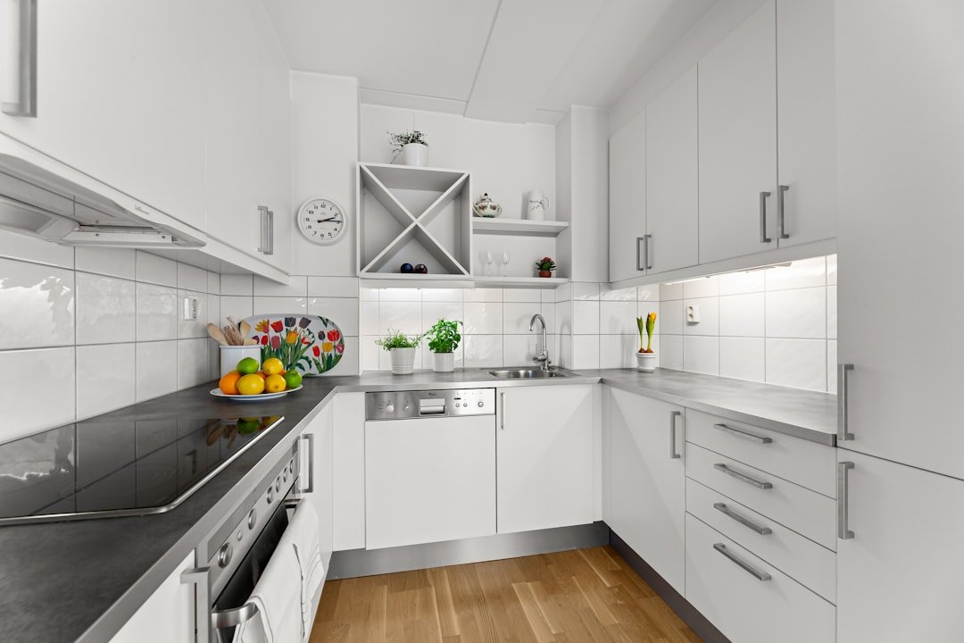 A kitchen with white cabinets and black counter tops