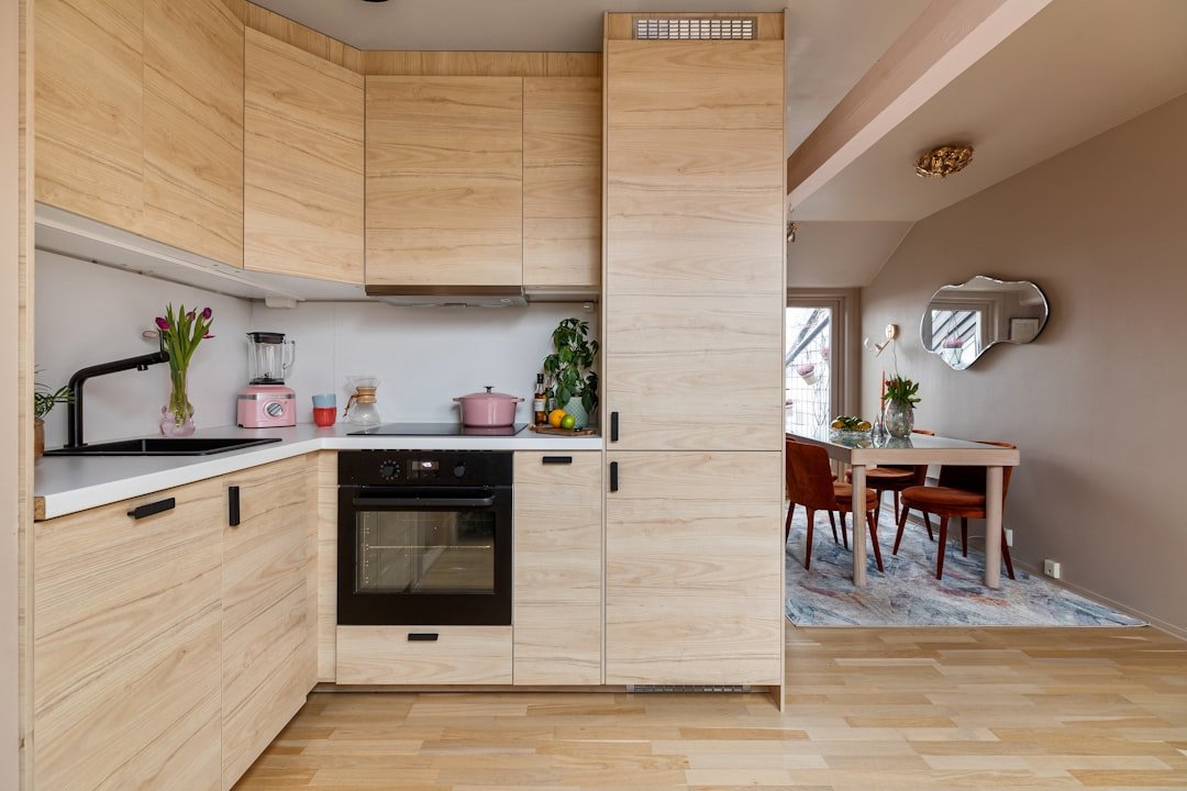 A kitchen with a stove top oven next to a dining room table