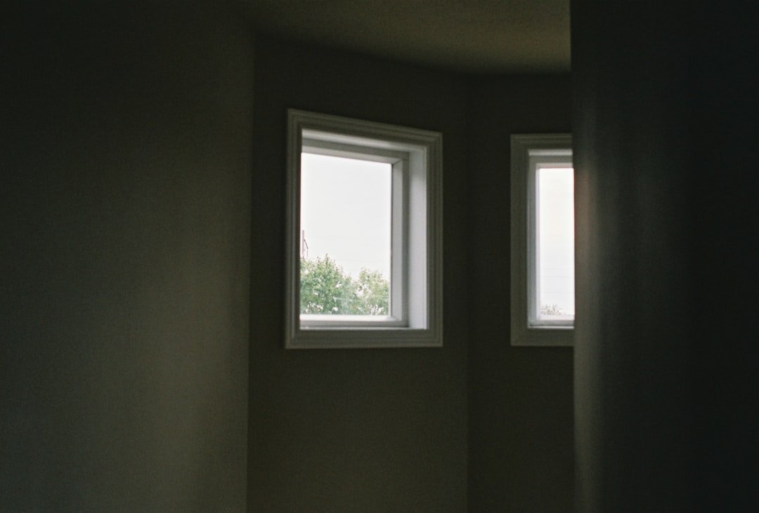 a room with two windows and a toilet