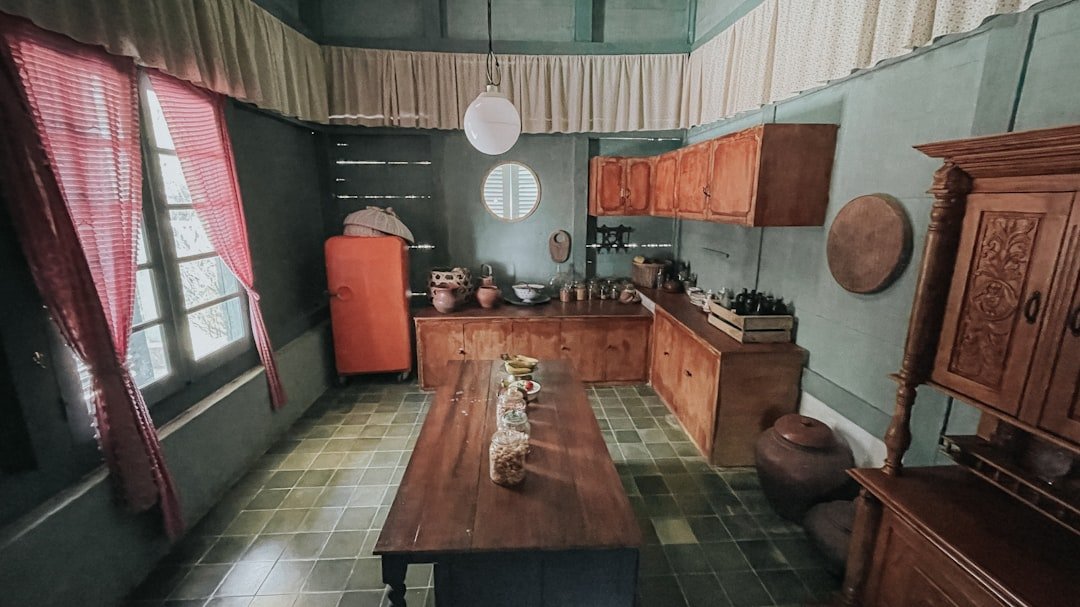 a kitchen with a table, cabinets, and a refrigerator