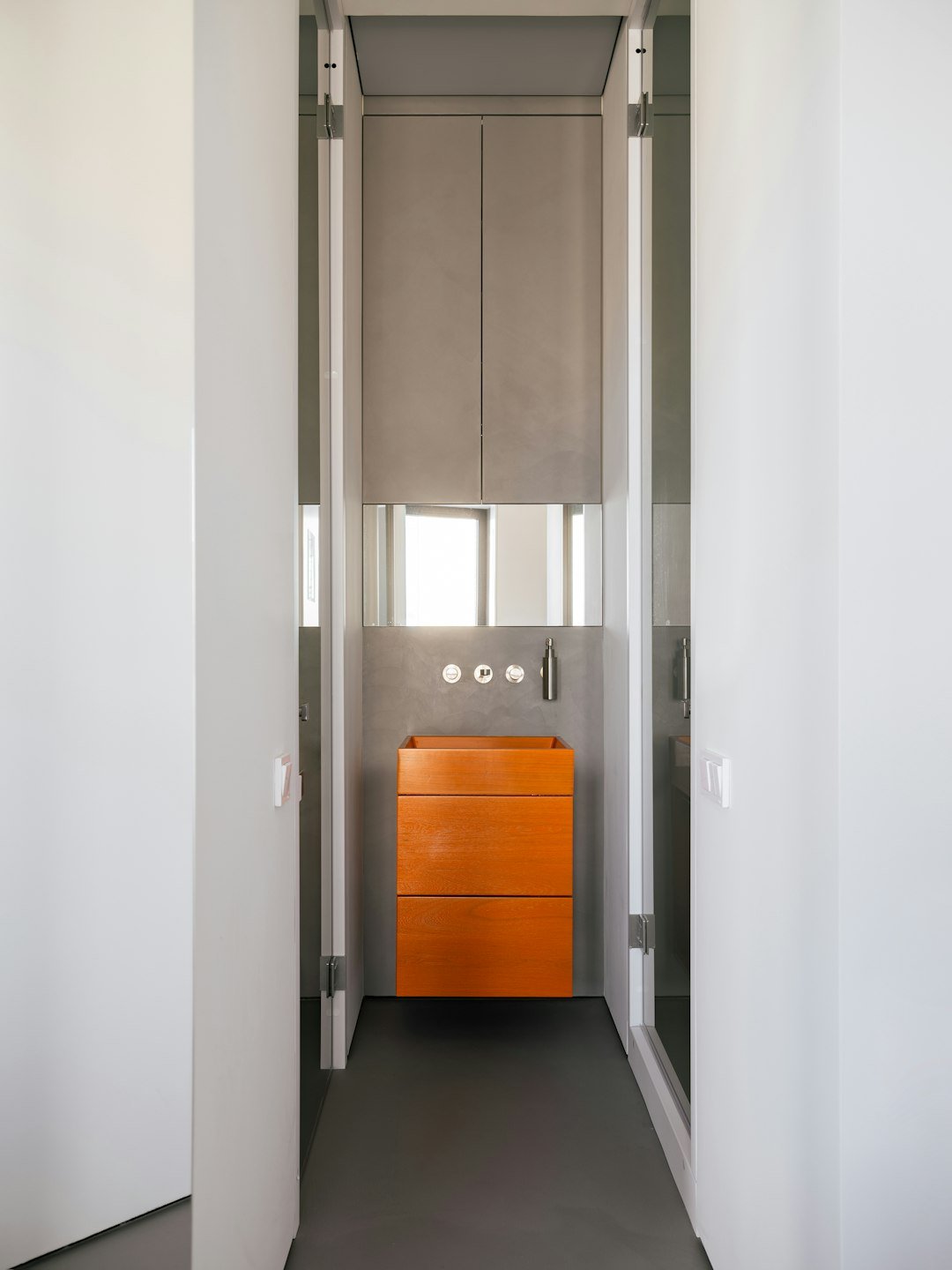 Modern bathroom with an orange vanity.