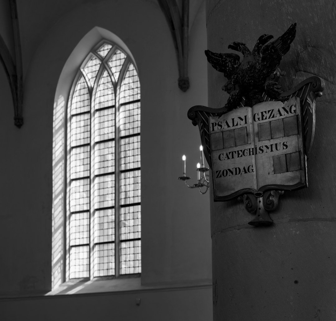 A black and white photo of a church with a stained glass window