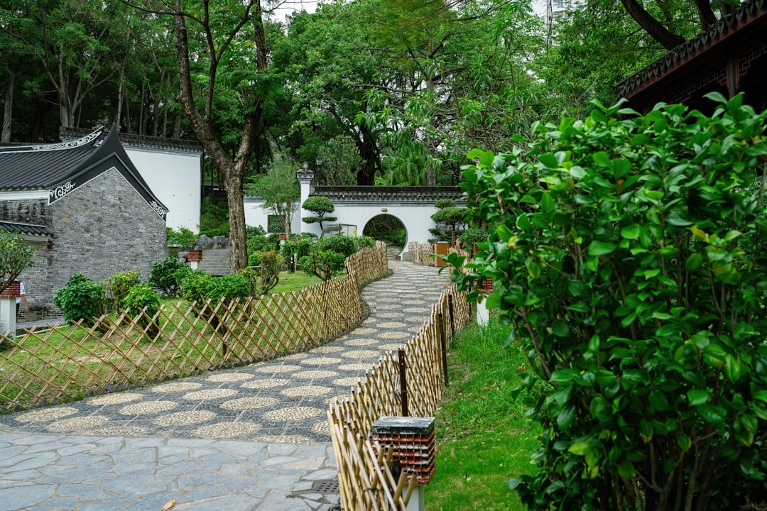 a stone path leads to a white building with a black roof