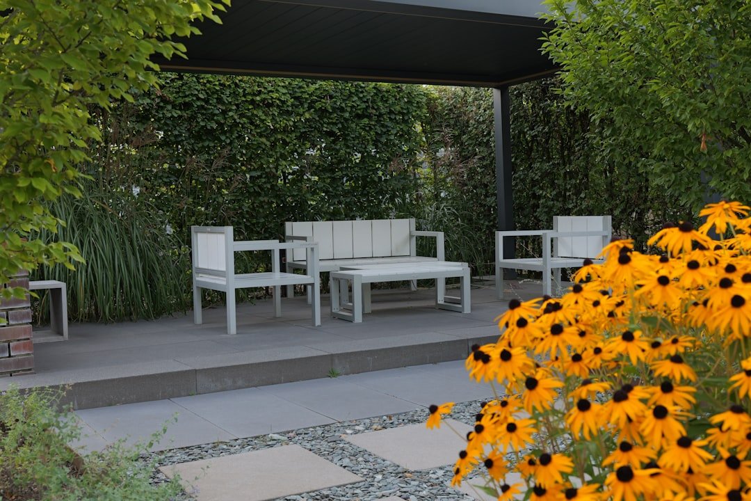 A white bench sitting next to a bunch of yellow flowers