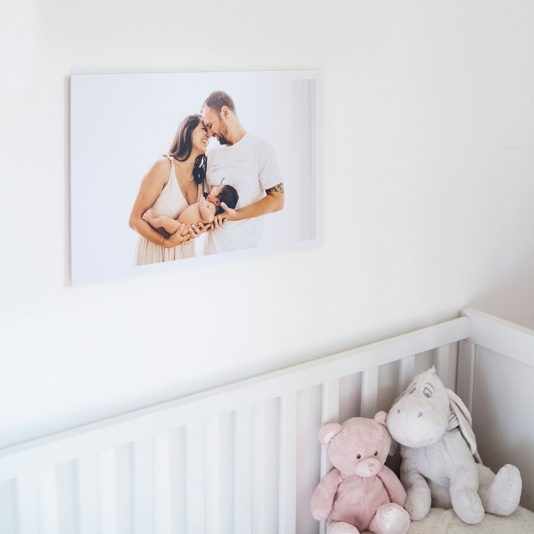 a baby's room with a picture of a man and woman on the wall