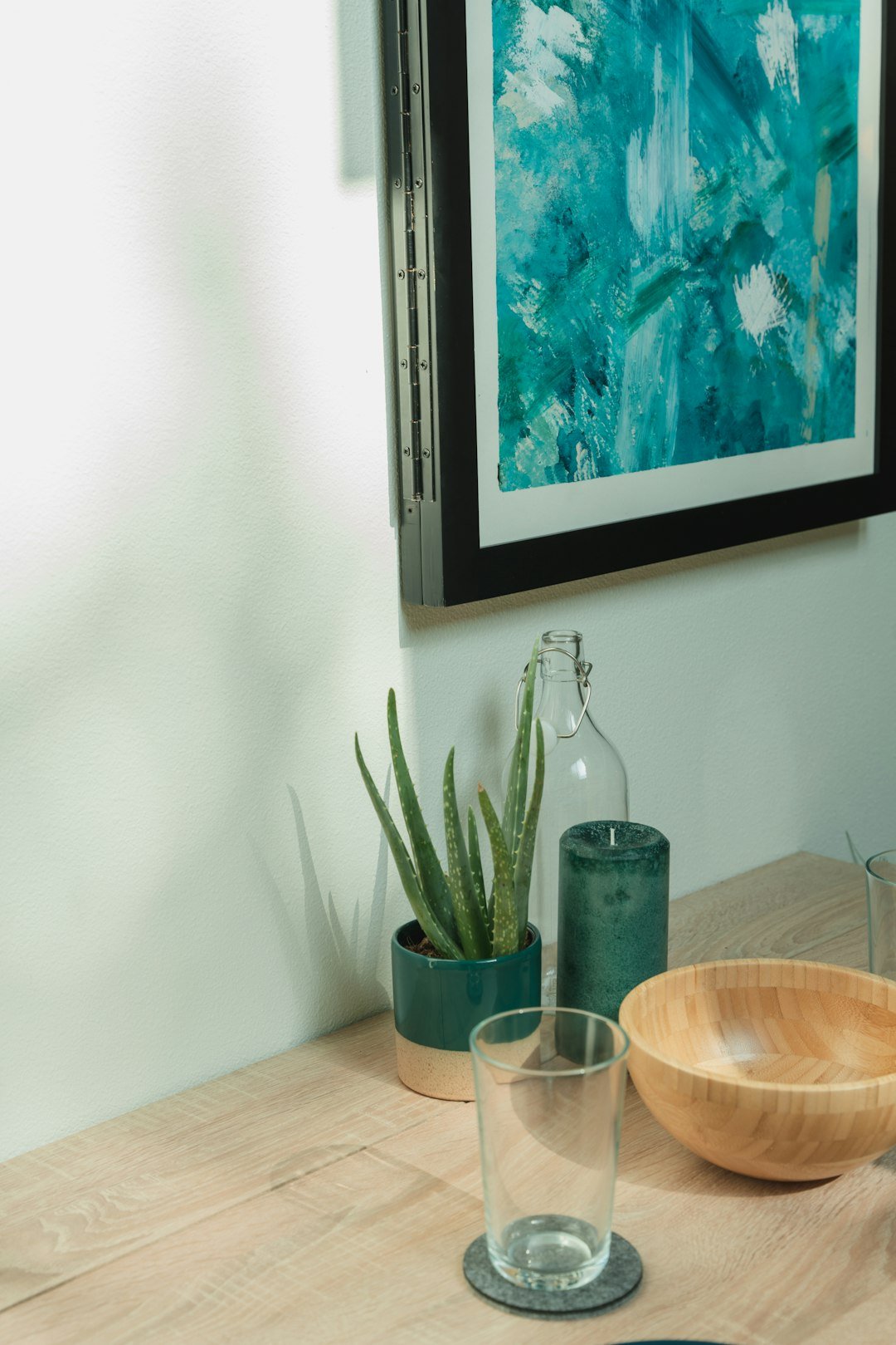 a wooden table topped with a bowl and two glasses
