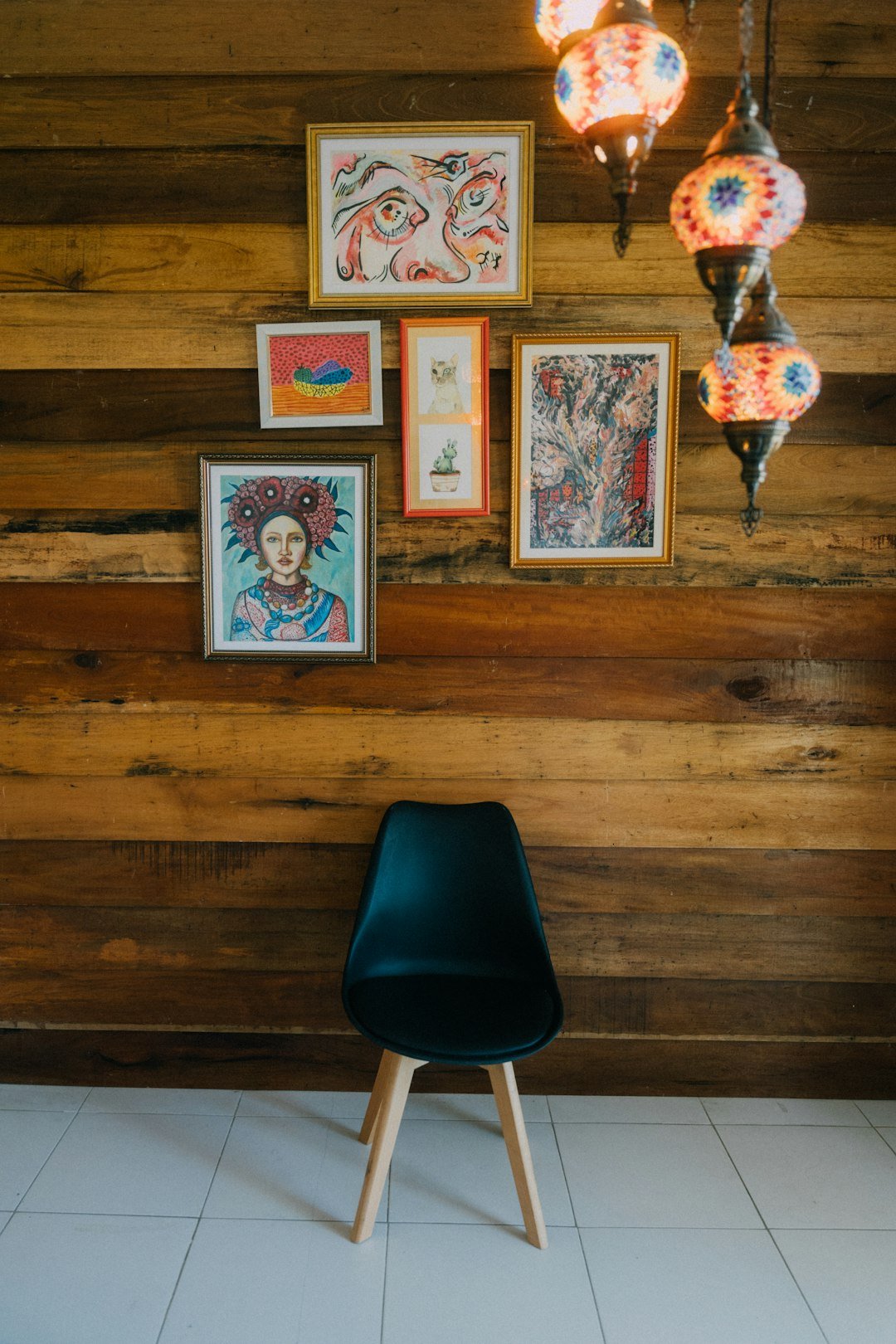 A black chair sitting in front of a wooden wall