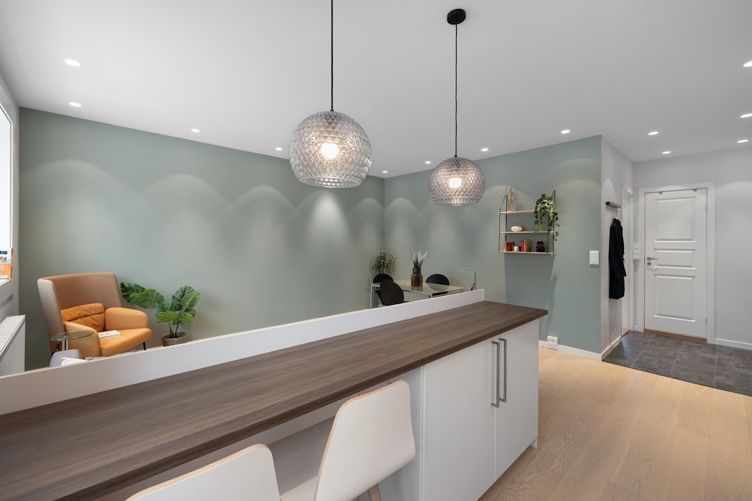 A kitchen with a counter, chairs and a bar