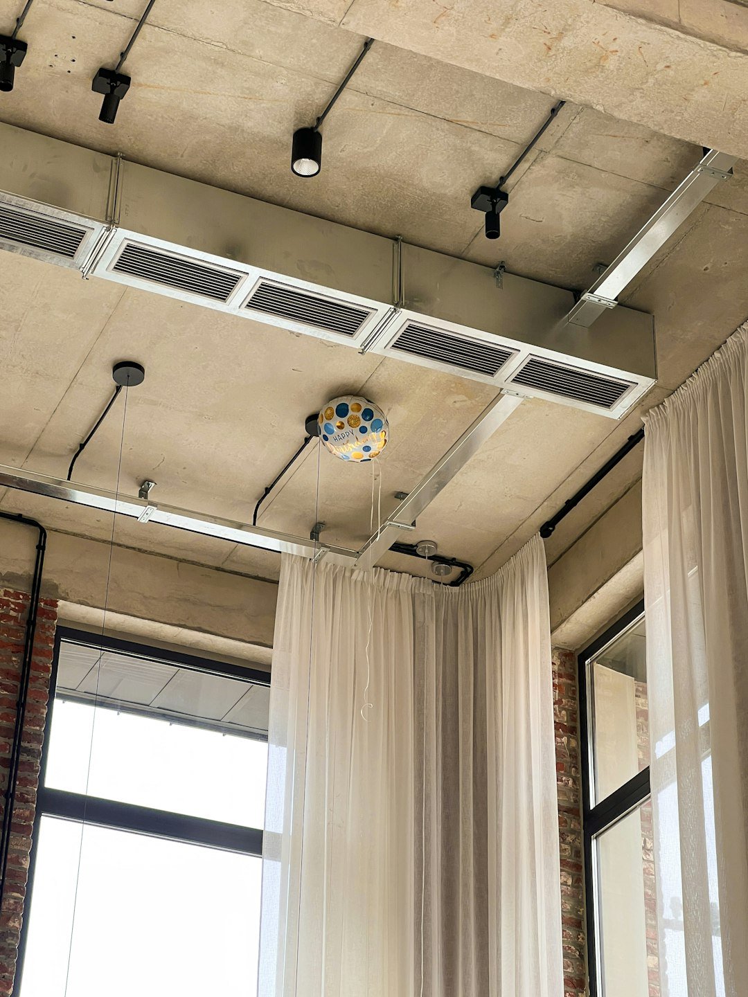 a room with a ceiling fan and curtains