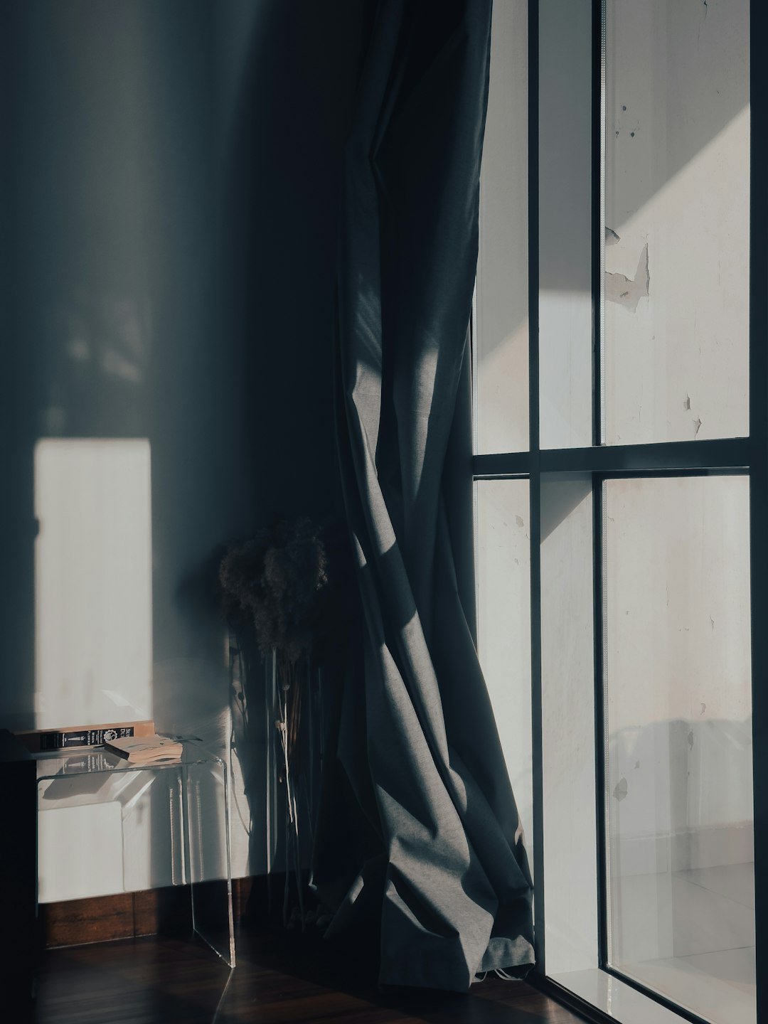 A room with a large window and a wooden floor